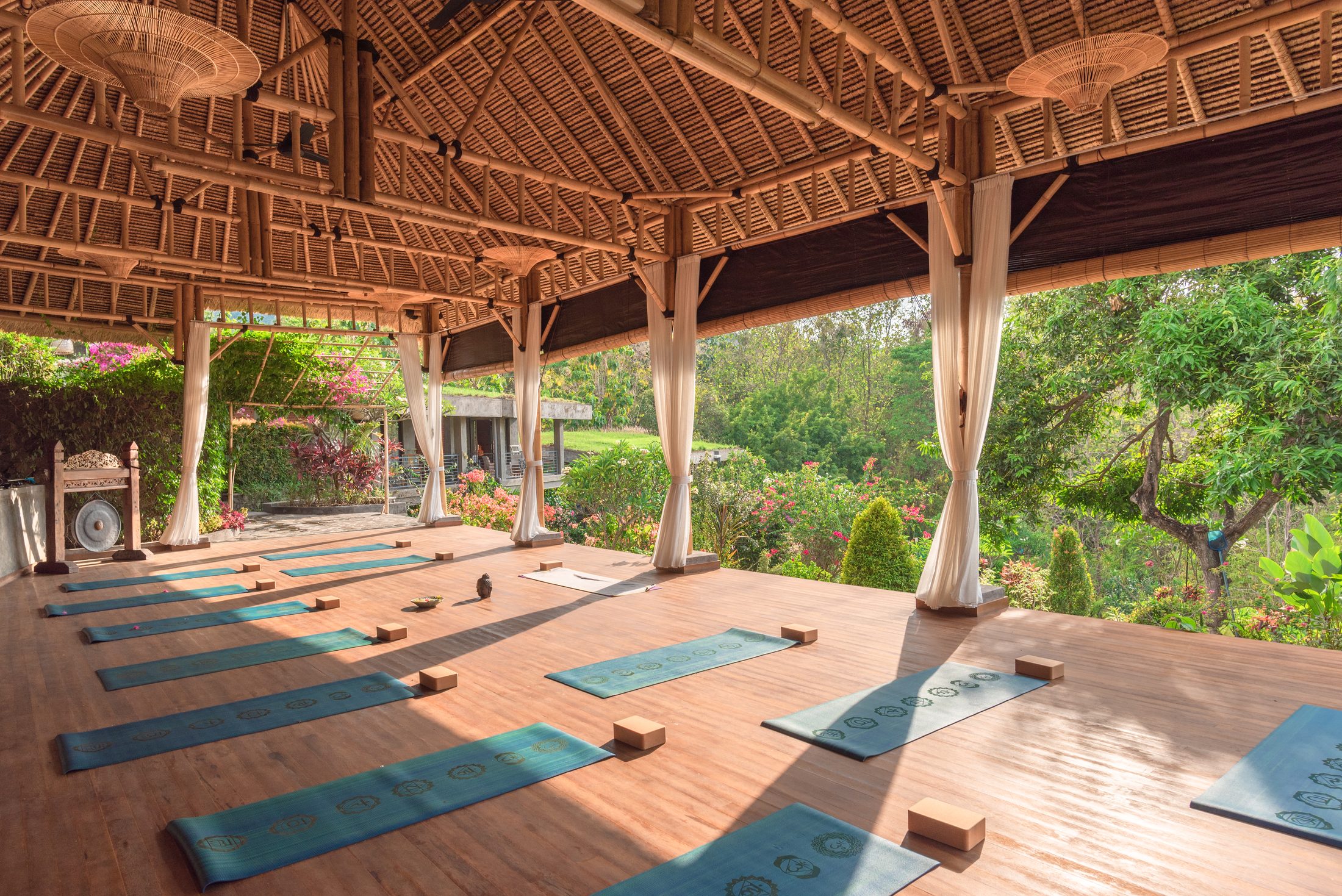 Wide view of the Alamanda Yoga Shala with mats laid out and jungle beyond